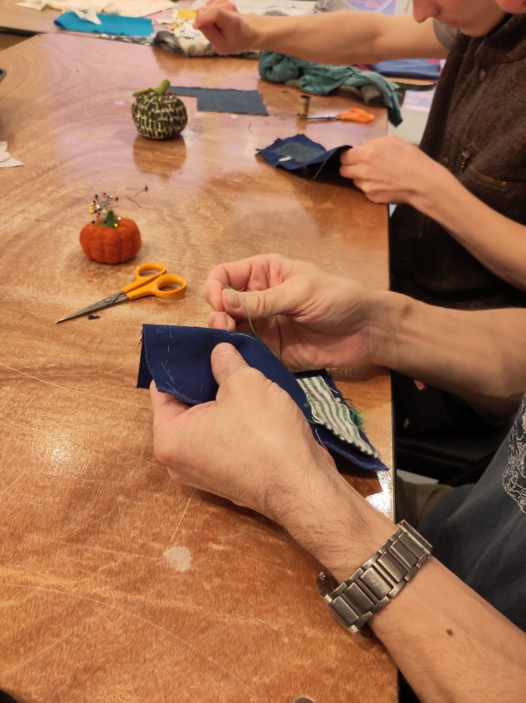 Person practicing mending on scrap piece of fabric